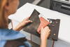 a woman with her wallet open at a counter taking her passport out